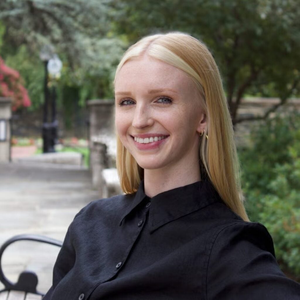 Soleil Slawson sitting on a bench, wearing a black button-down shirt