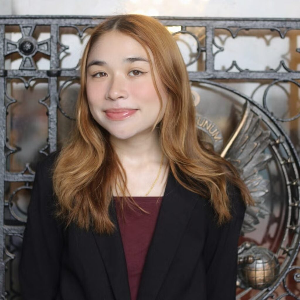 Sophia Epley wearing a black blazer and a burgundy shirt.