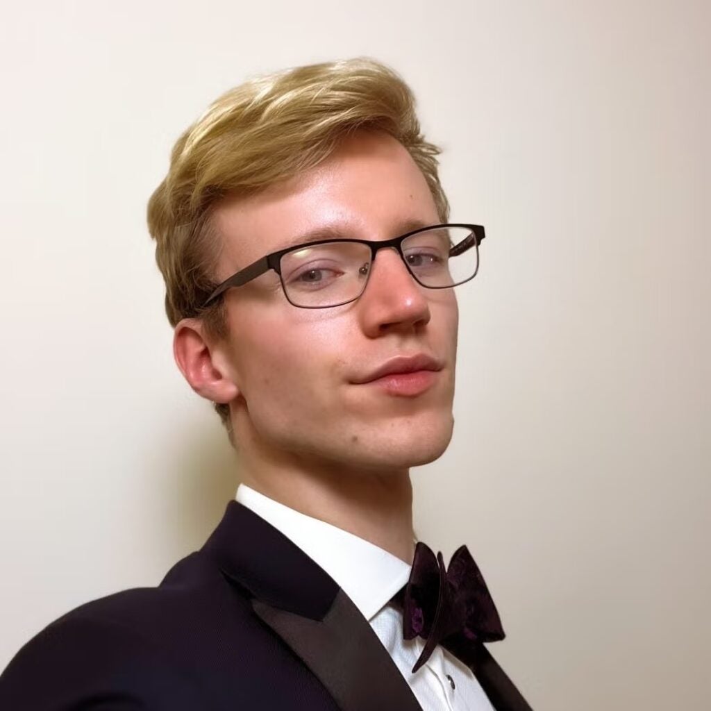 Tobias Toby Mayhew wearing glasses and a tuxedo