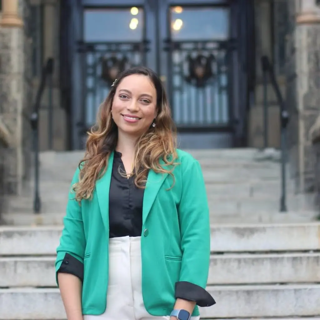 Veronica Uribe-Kessler wearing a turquoise-green blazer, cream pants, and a black button-down shirt.