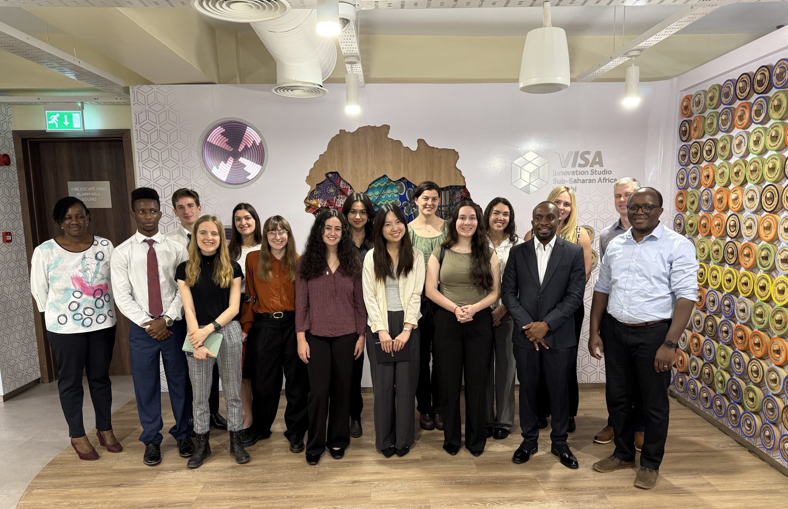 Group of professionals standing together in an office branded with Visa logos.