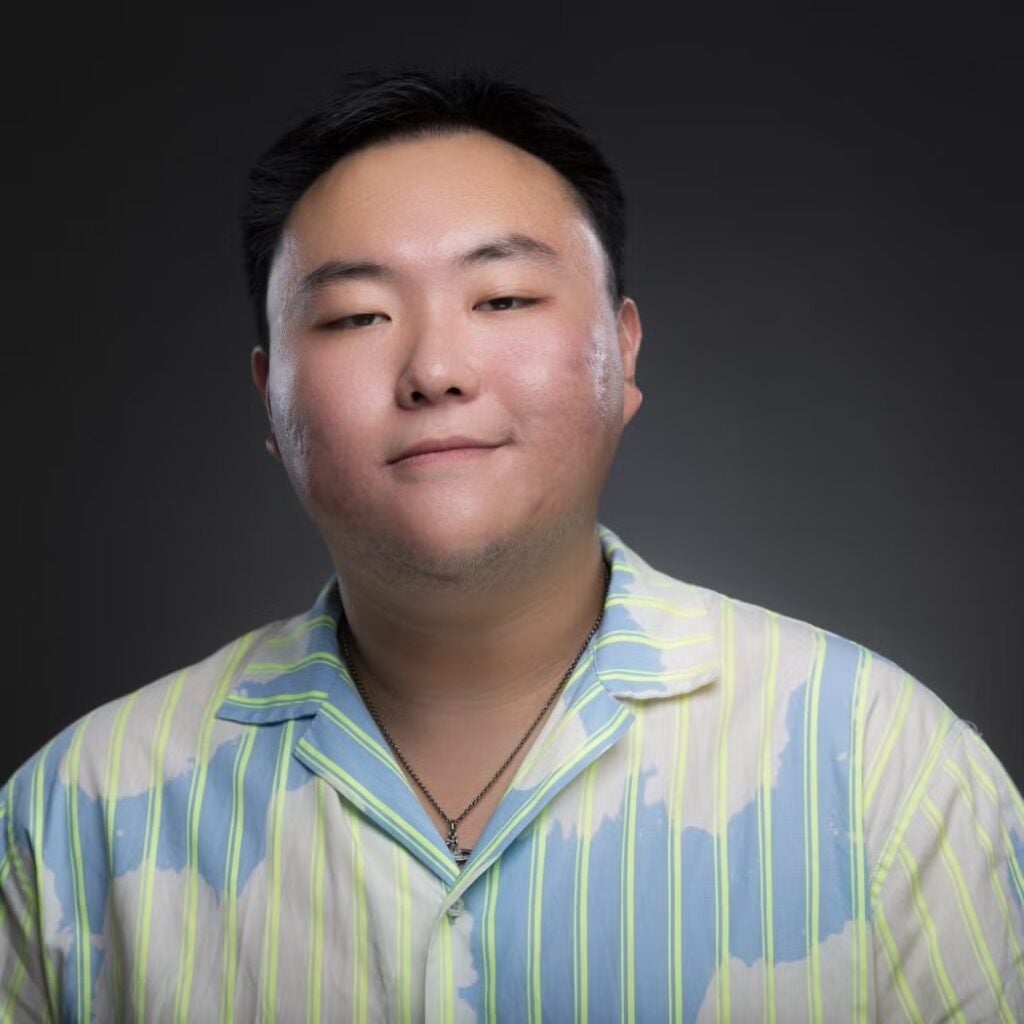 Zidong Anson Zhang wearing a blue and white shirt with yellow stripes.
