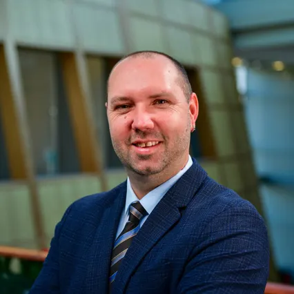 Headshot of Andrii Marchak wearing a navy blue suit.