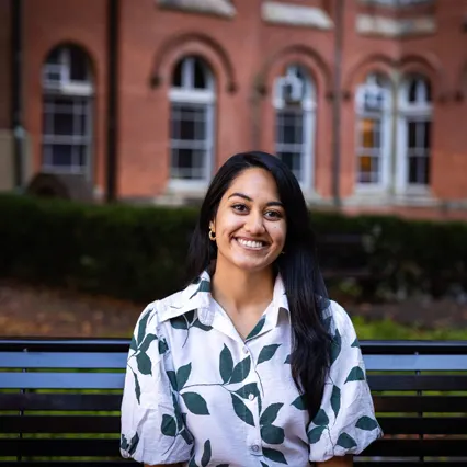 Headshot of Kritika Sharma smiling, wearing a white shirt with green leaves.