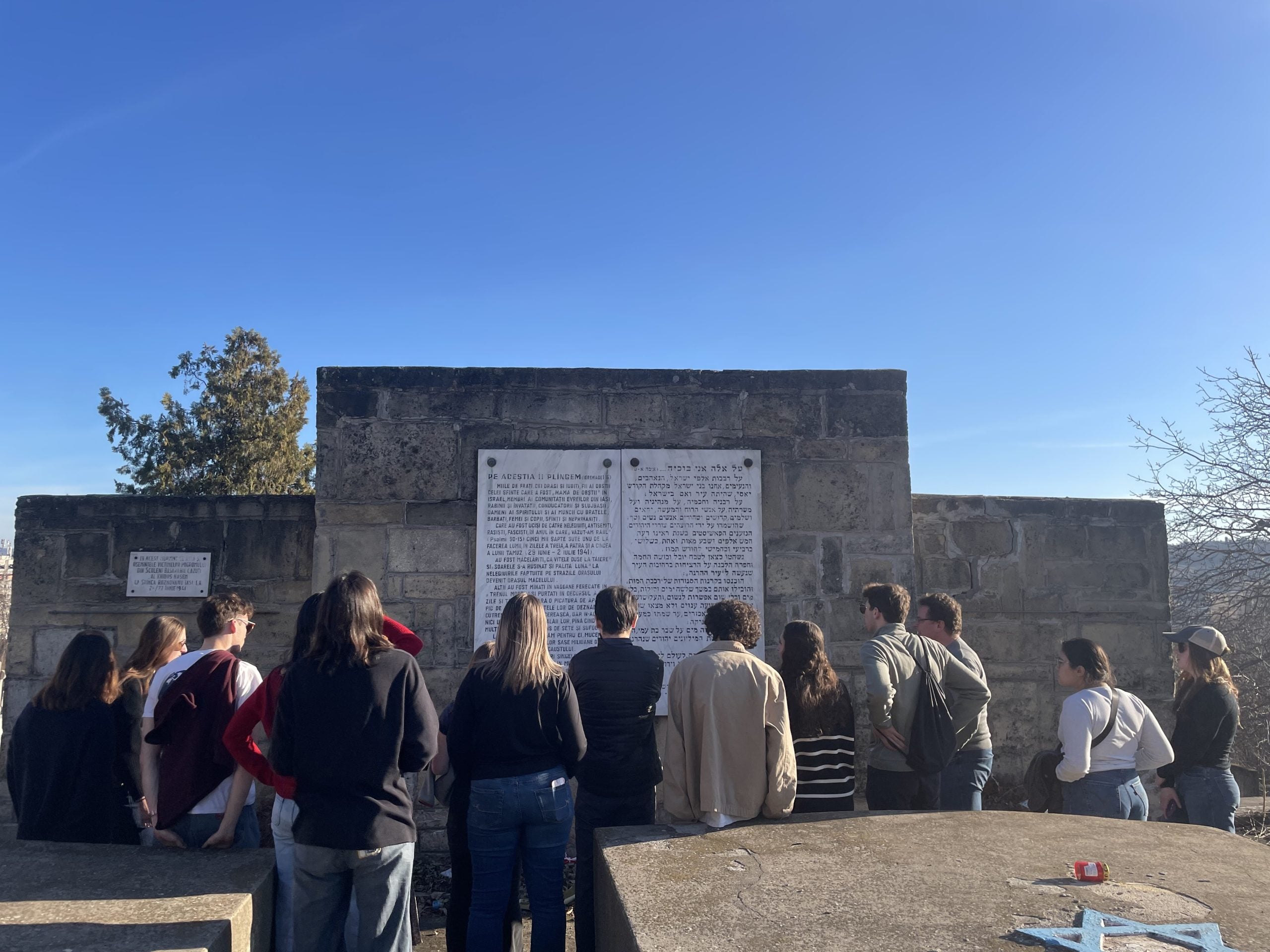 A group of college students reading an inscription at a mass grave.