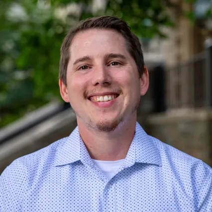 Headshot of Matt Hancock smiling, wearing a blue shirt.