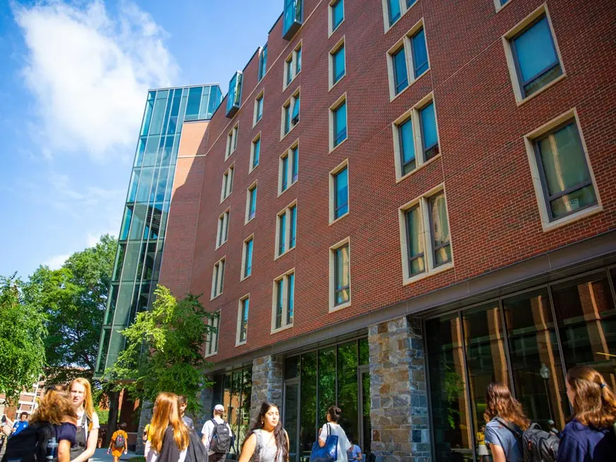 Brick student housing building, and students walking on campus.