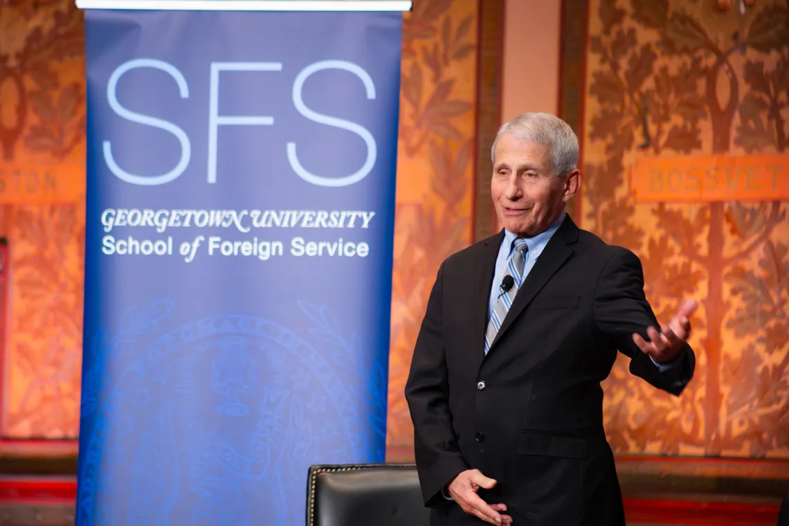 Dr. Fauci, standing on stage, behind him a banner of Georgetown University's School of Foreign Service