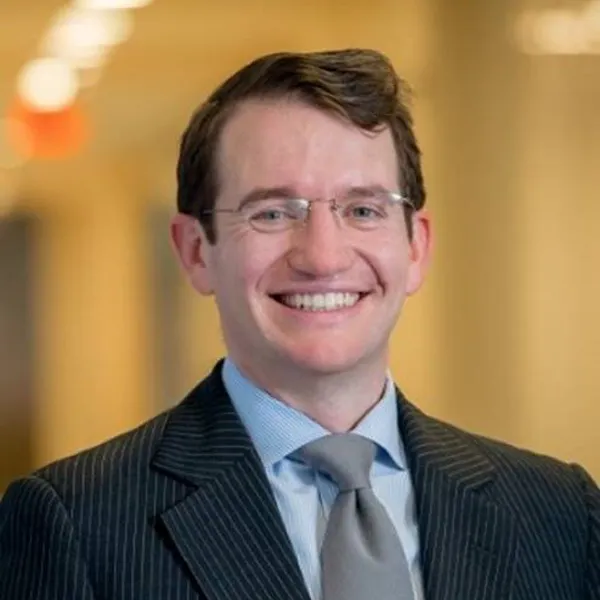 Headshot of a smiling Brendan Mullen, wearing a suit and tie.