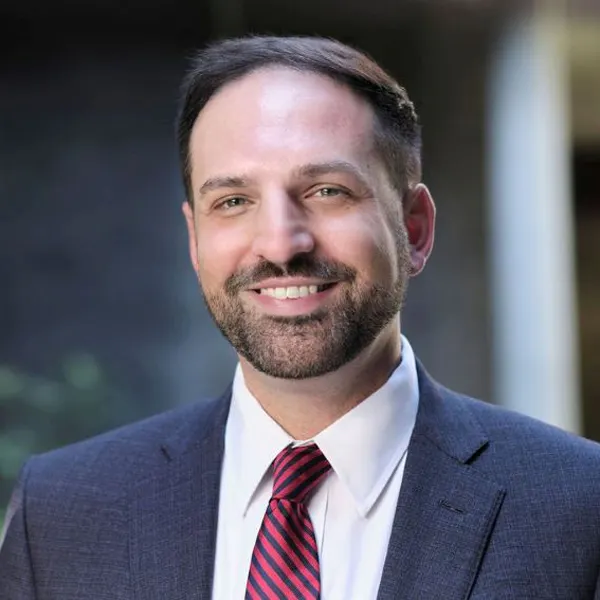 Headshot of a smiling Christopher Griffin wearing a suit.