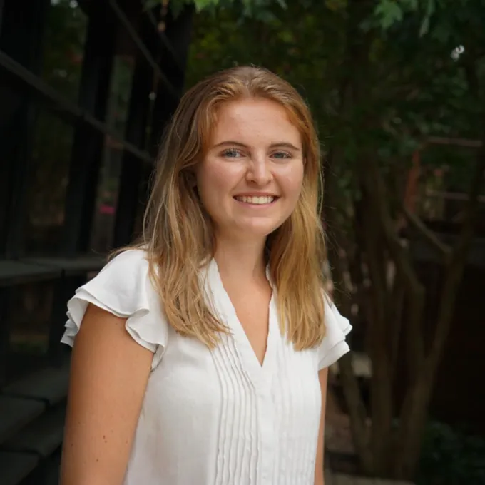 Headshot of Georgie Wilson smiling, wearing a white shirt.