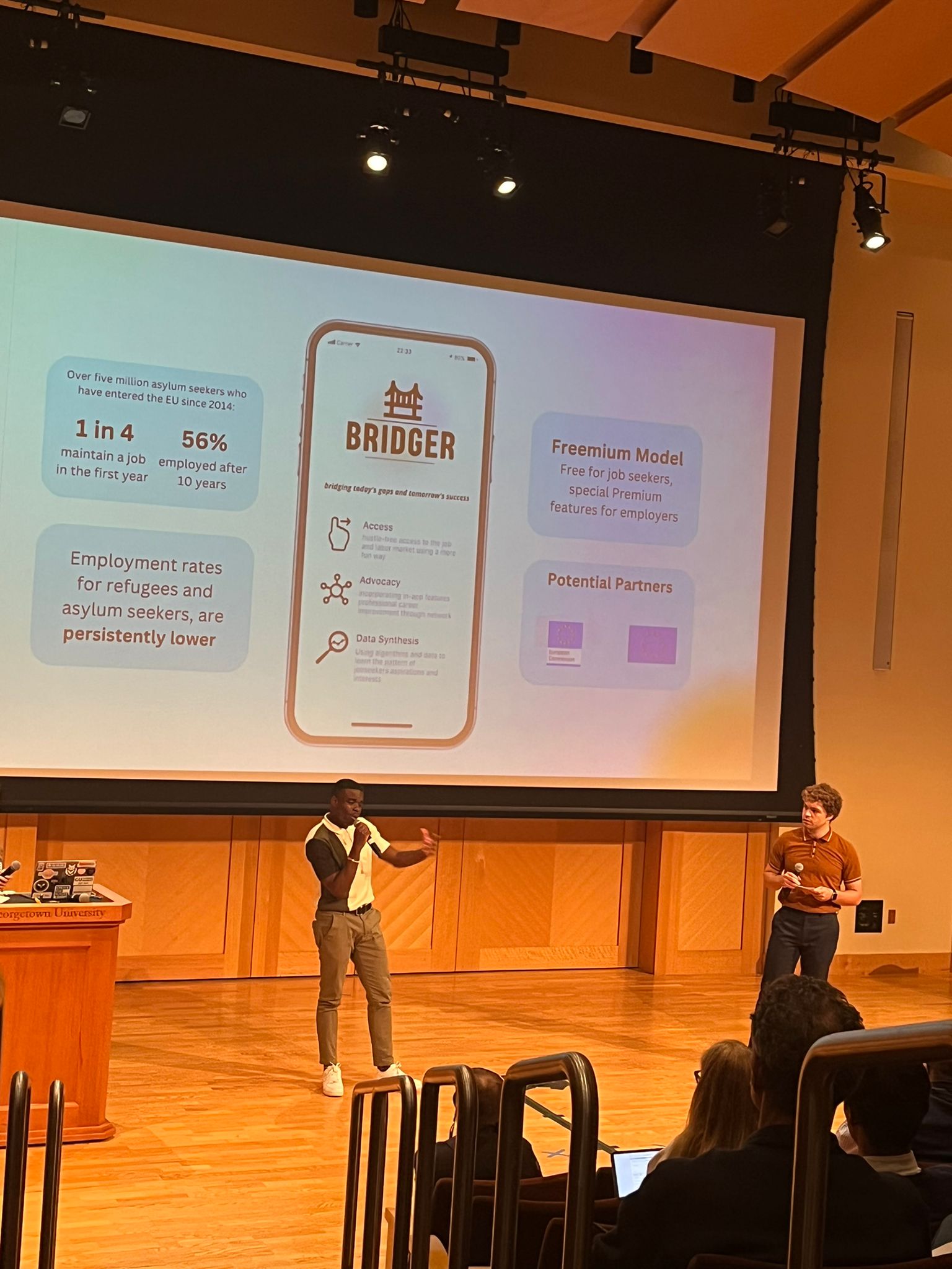 Photo of a student presenting their project Bridger on a stage.