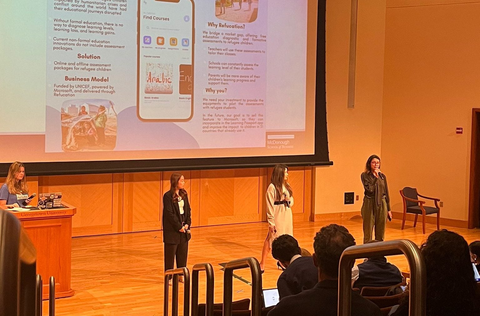 Photo of two students presenting on stage.