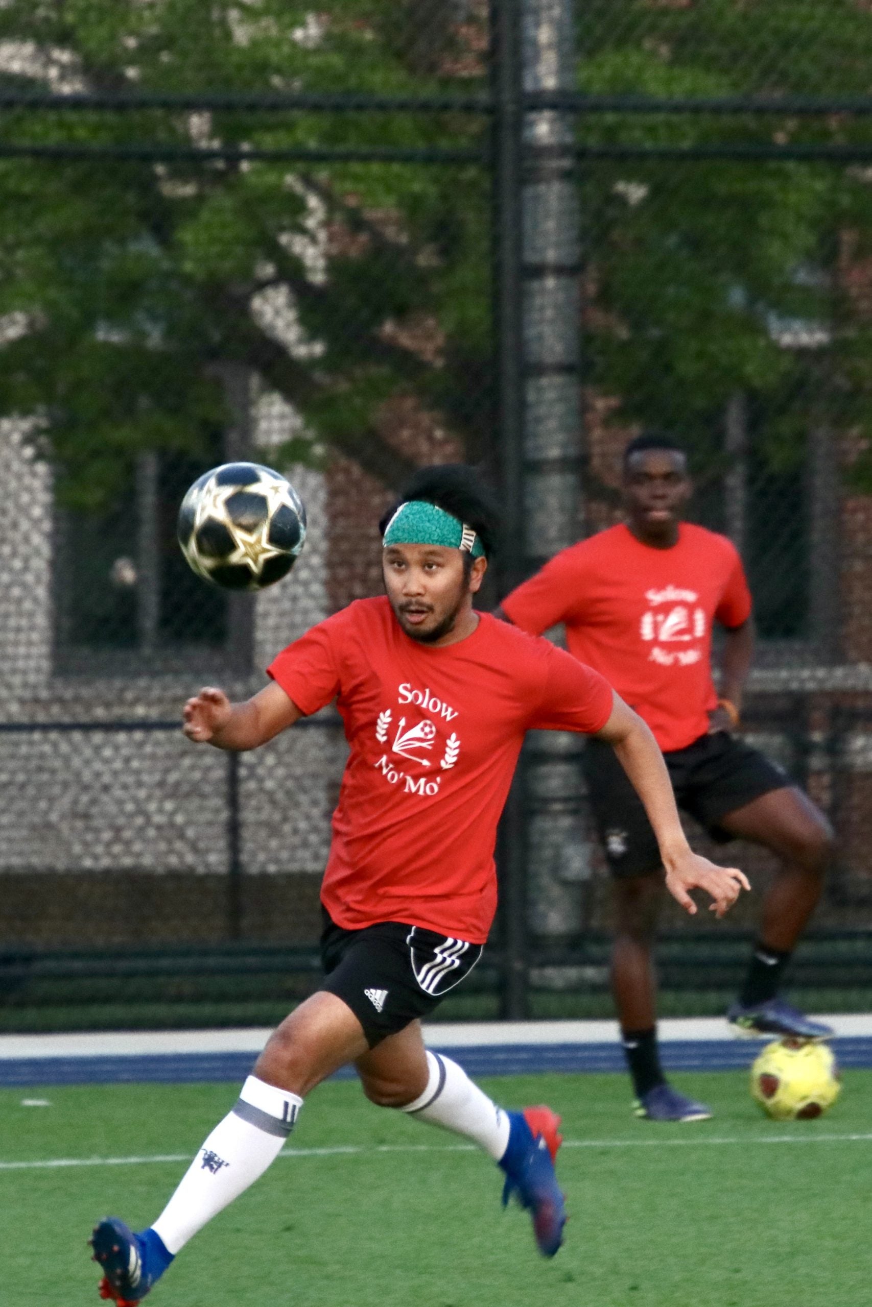 Photo of a GHD student looking at a football in air, getting ready to hit.