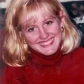 Photo of Paula Gene Loyd, smiling, wearing a red turtleneck.