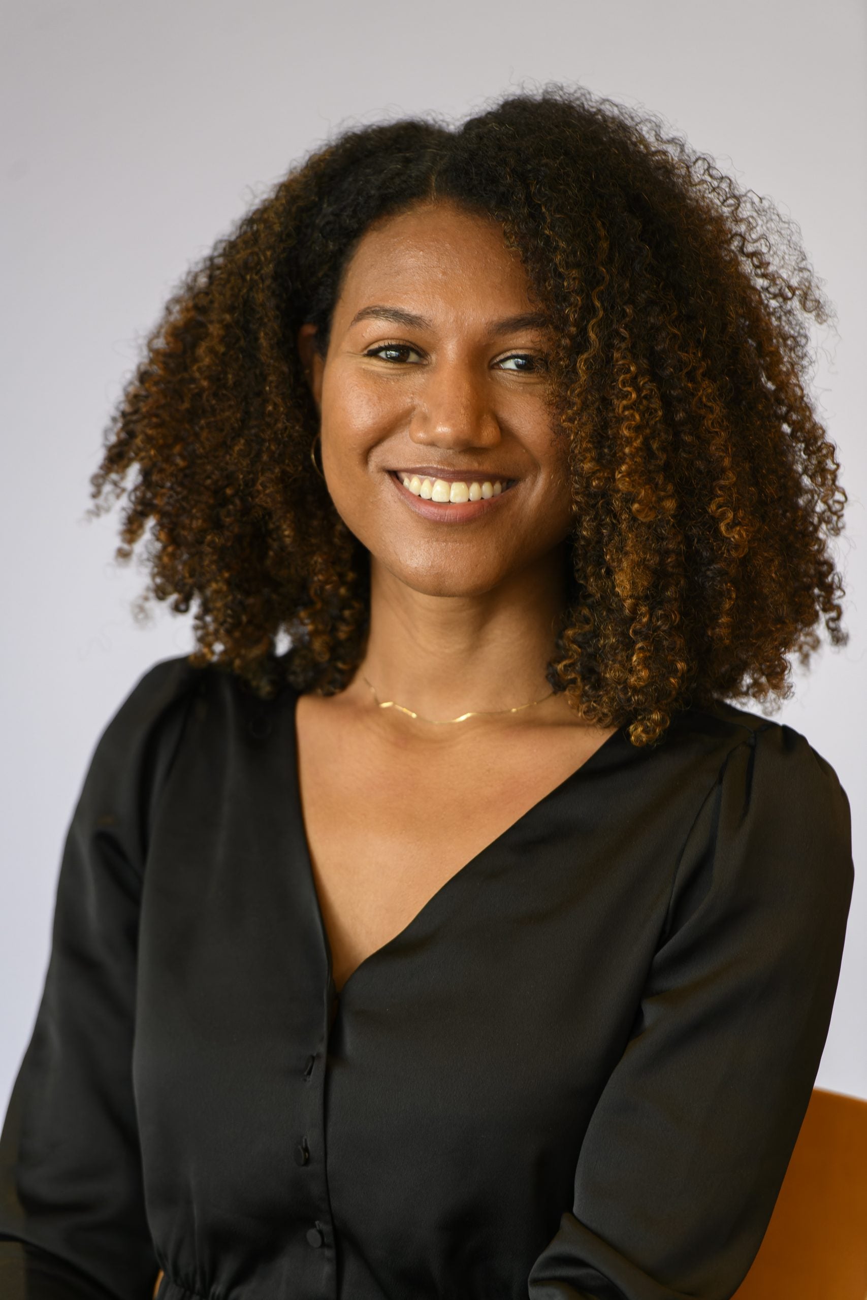 Headshot of Katie-Meelel Nodjimbadem, smiling, wearing a black blouse.