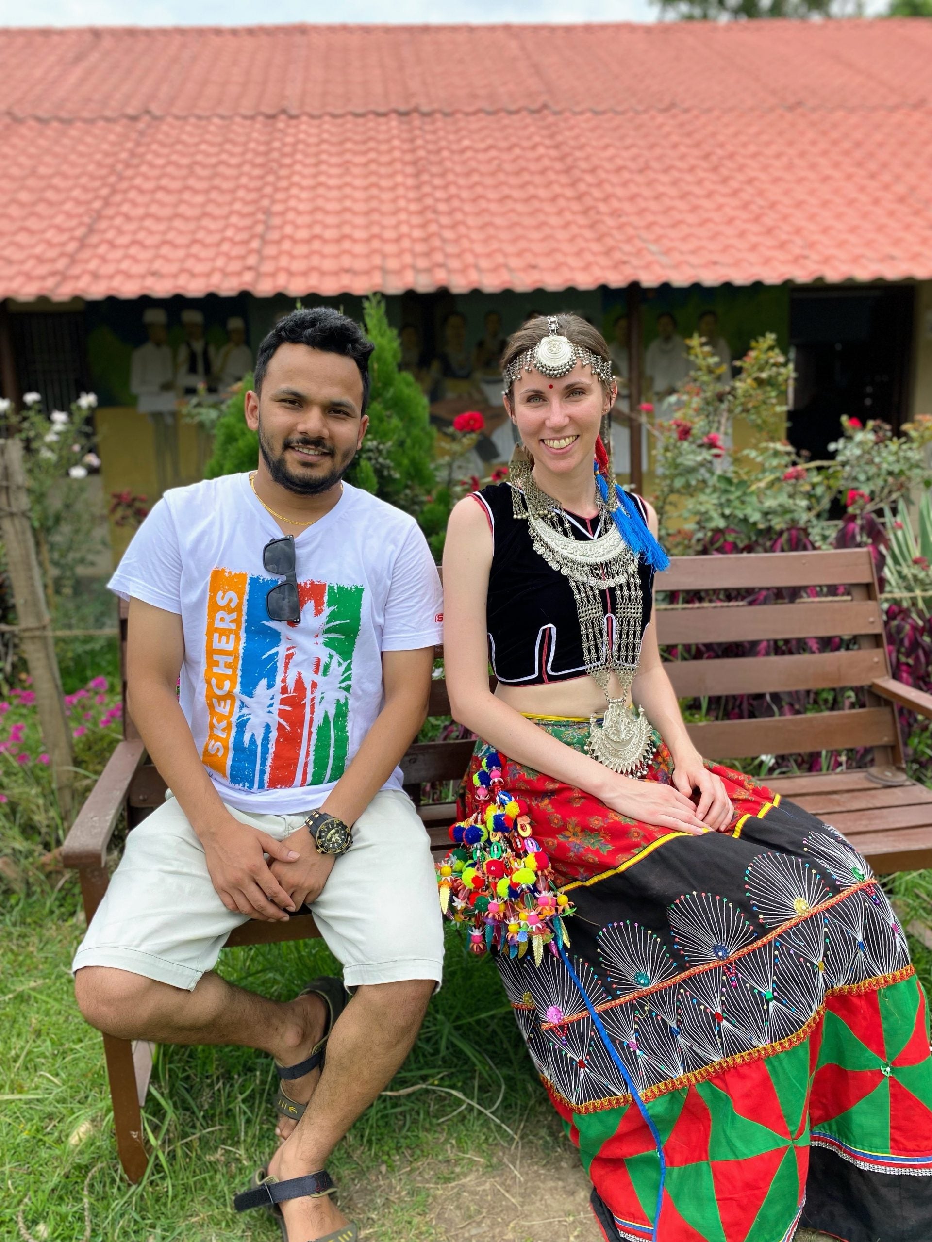 Therese wearing a Tharu ceremonial dress and posing next to a BASE/NEFAD staff member.