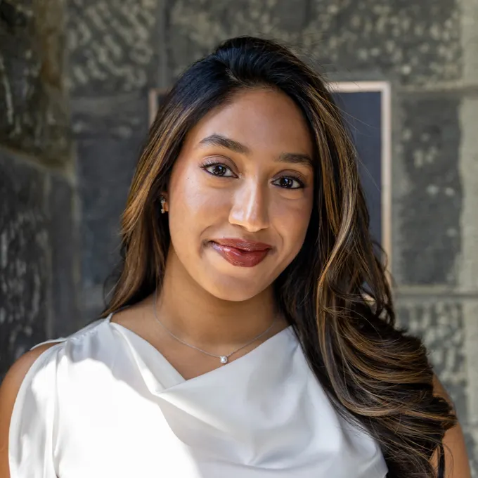 Headshot of a smiling Naina Bhamidipati wearing a white shirt.