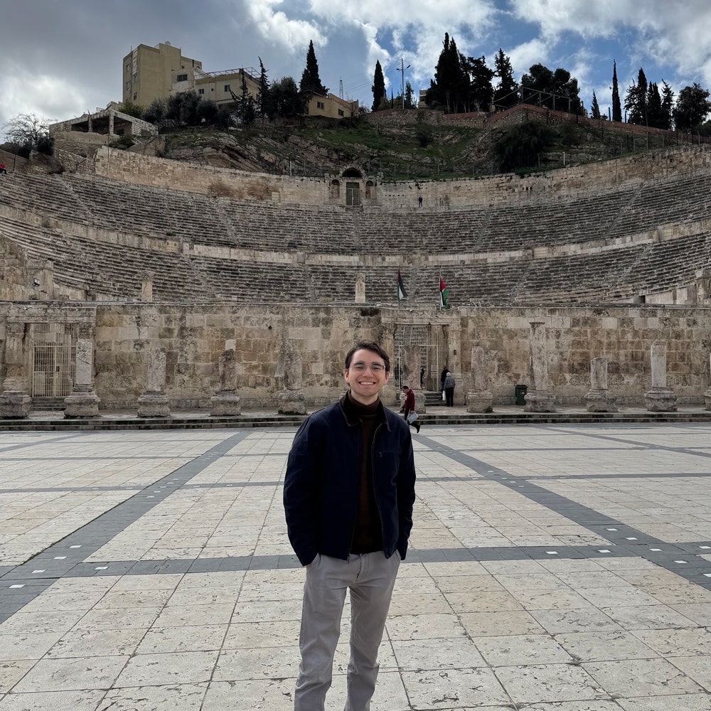 Young man standing in front of Roman ruins in Amman