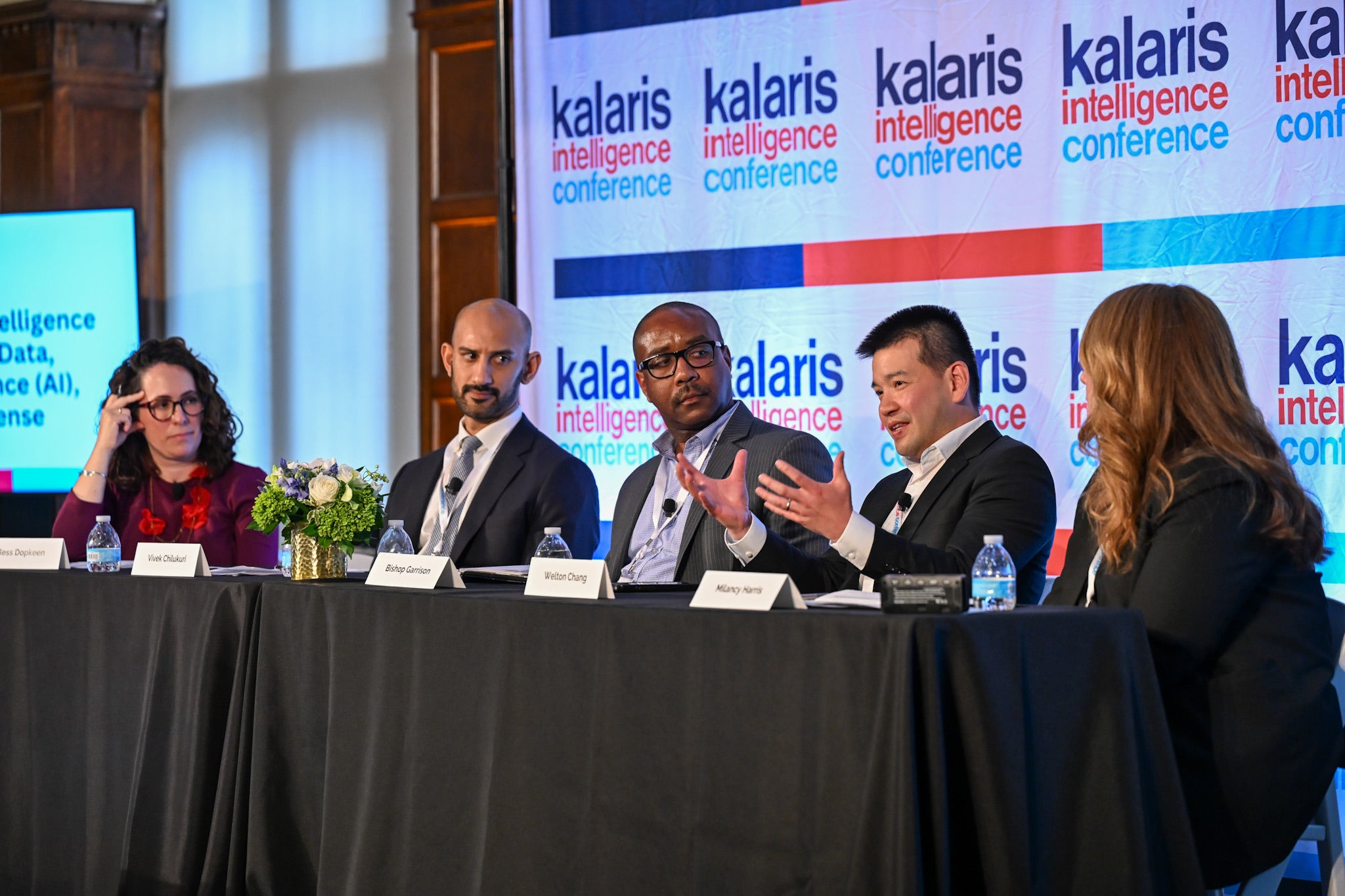 Five people sitting around a table in a panel discussion. Behind them a backdrop with the words "kalaris intelligence conference" 