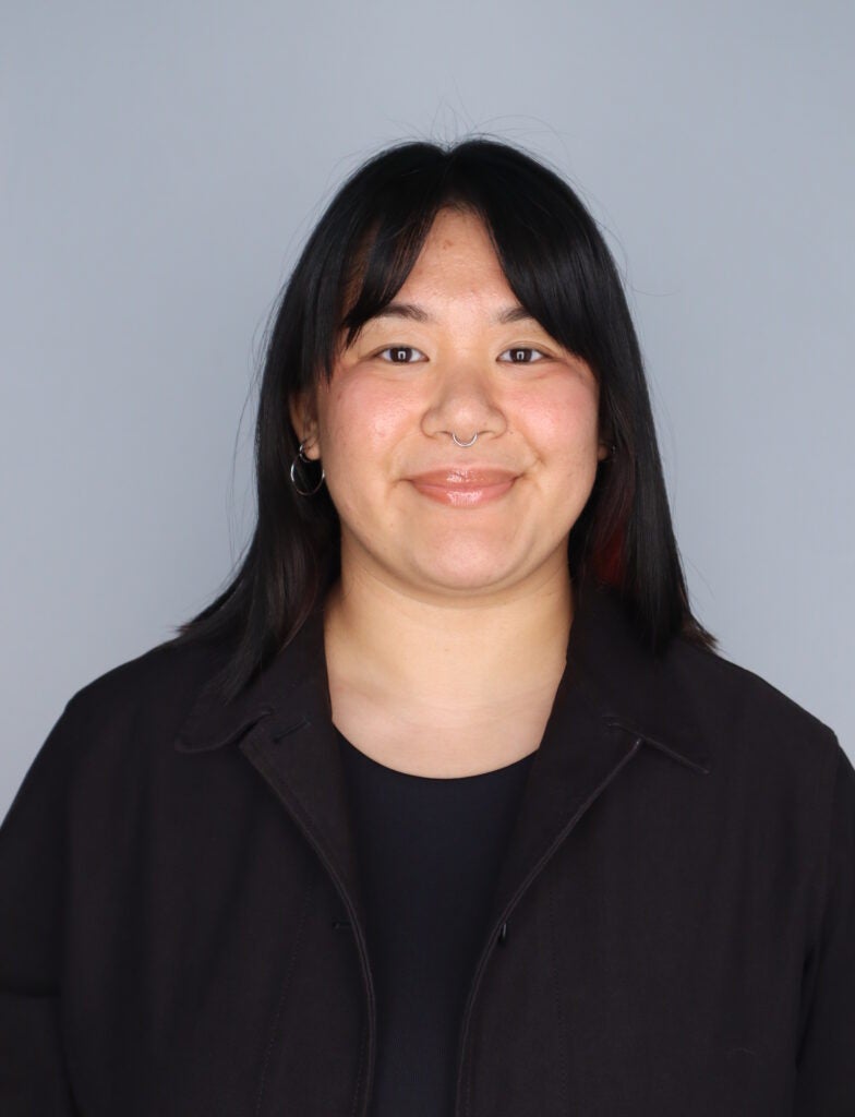 Headshot of Jenna DeFosse, smiling, wearing black clothes