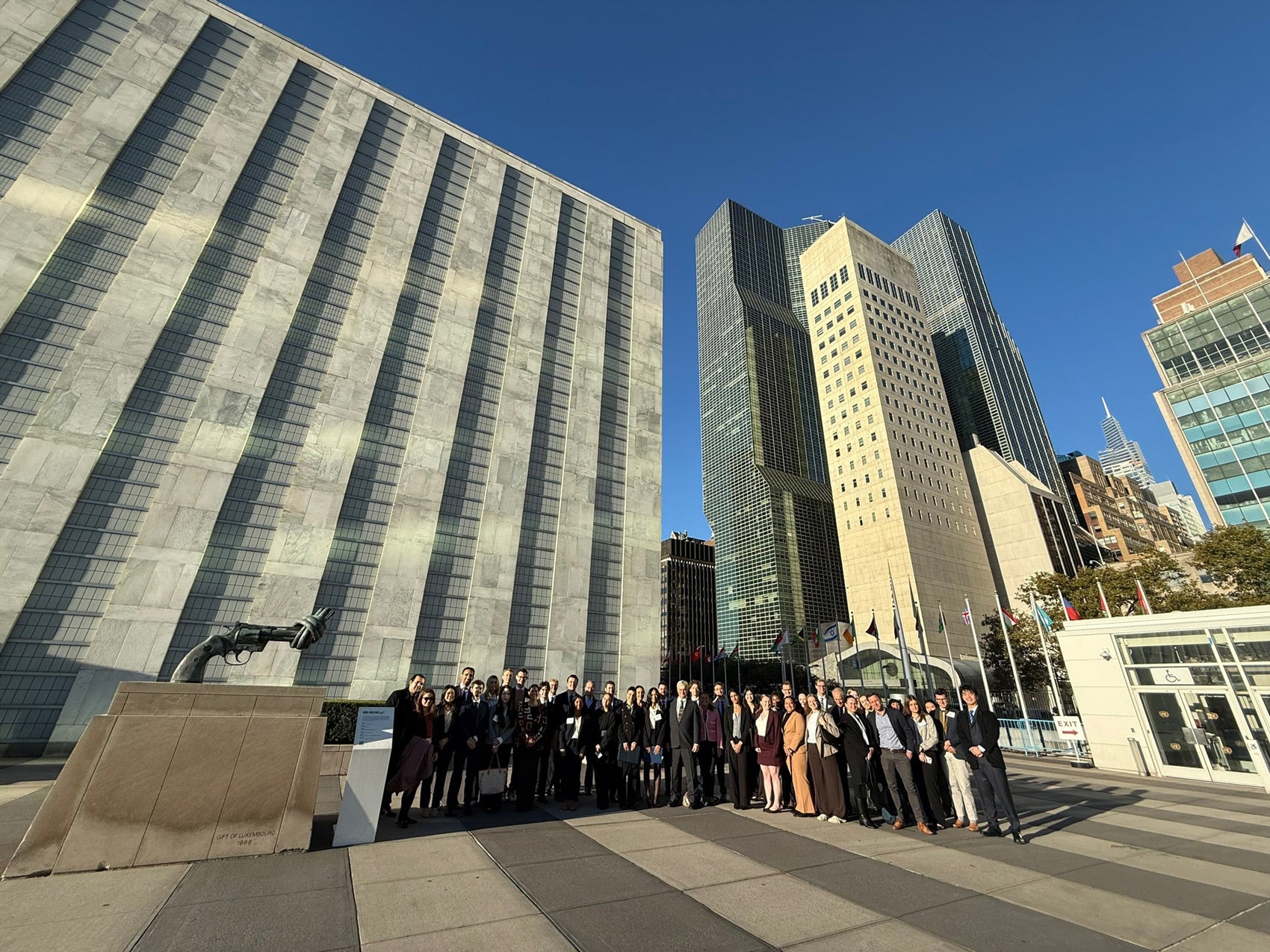 Group of 40 MSFS students outside of the United Nations Headquarters. Surrounded by high-rise buildings.