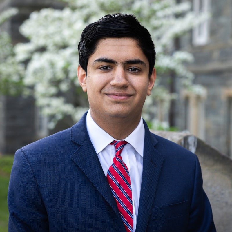 Headshot of Peer KHAN smiling, wearing a suit