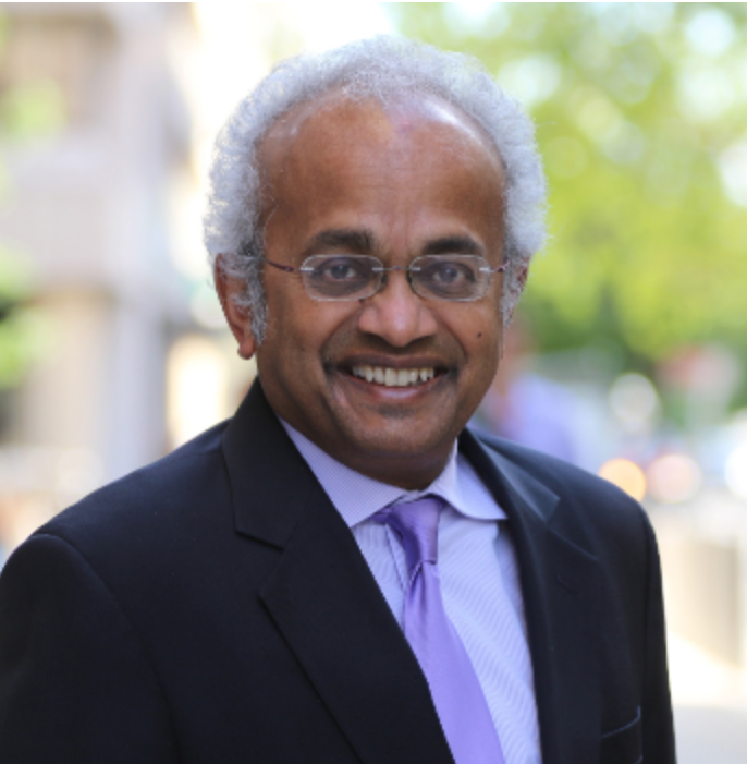 Headshot of Professor Shantayanan Devarajan smiling, wearing a suit