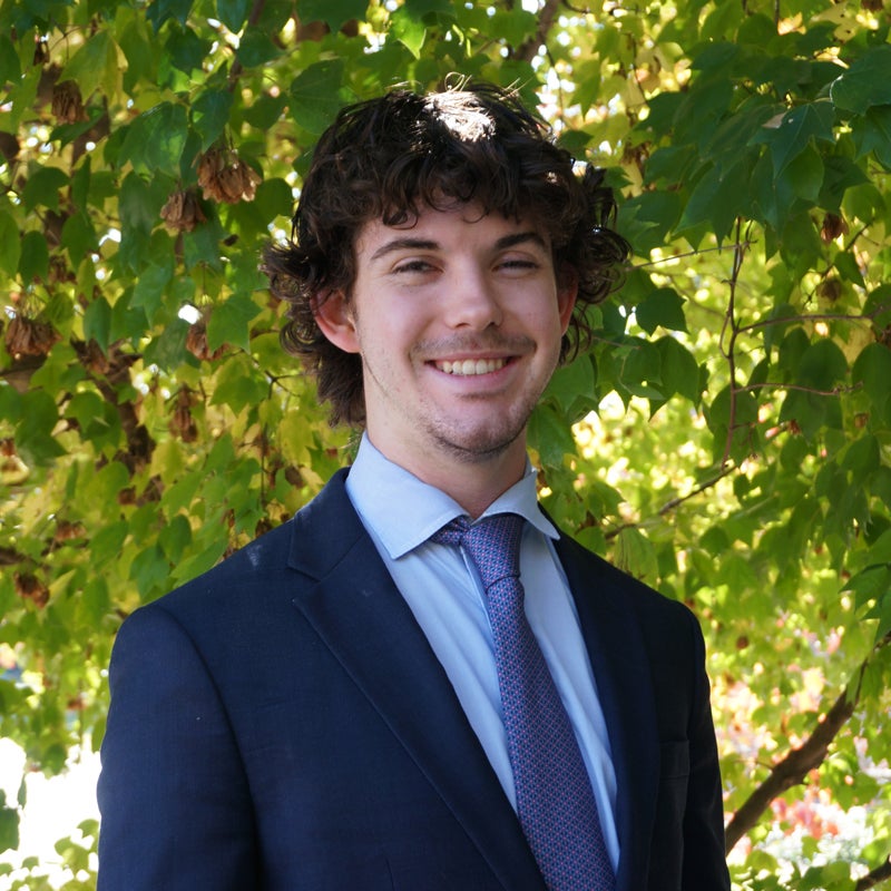Headshot of Ben Whitfield smiling wearing business attire