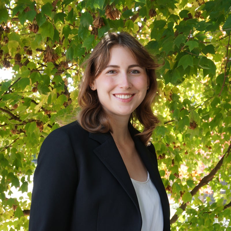 Headshot of Courtney Powers smiling wearing business attire