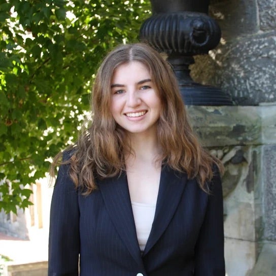 Headshot of Maya B smiling wearing business attire