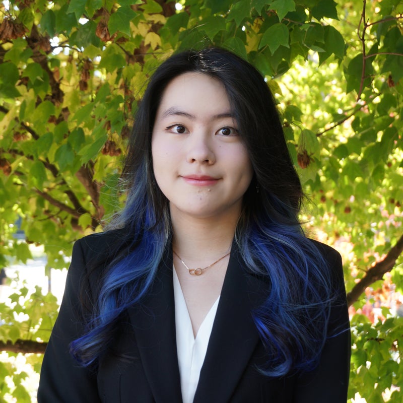 Headshot of Mina Zhang smiling wearing business attire