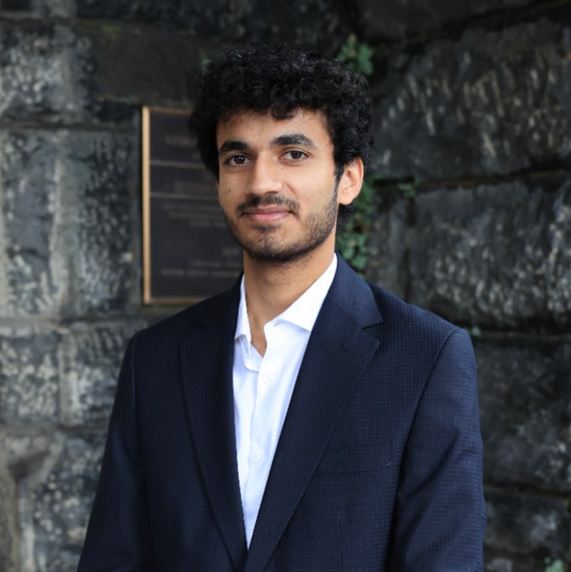 Headshot of Rai Hasen wearing business attire