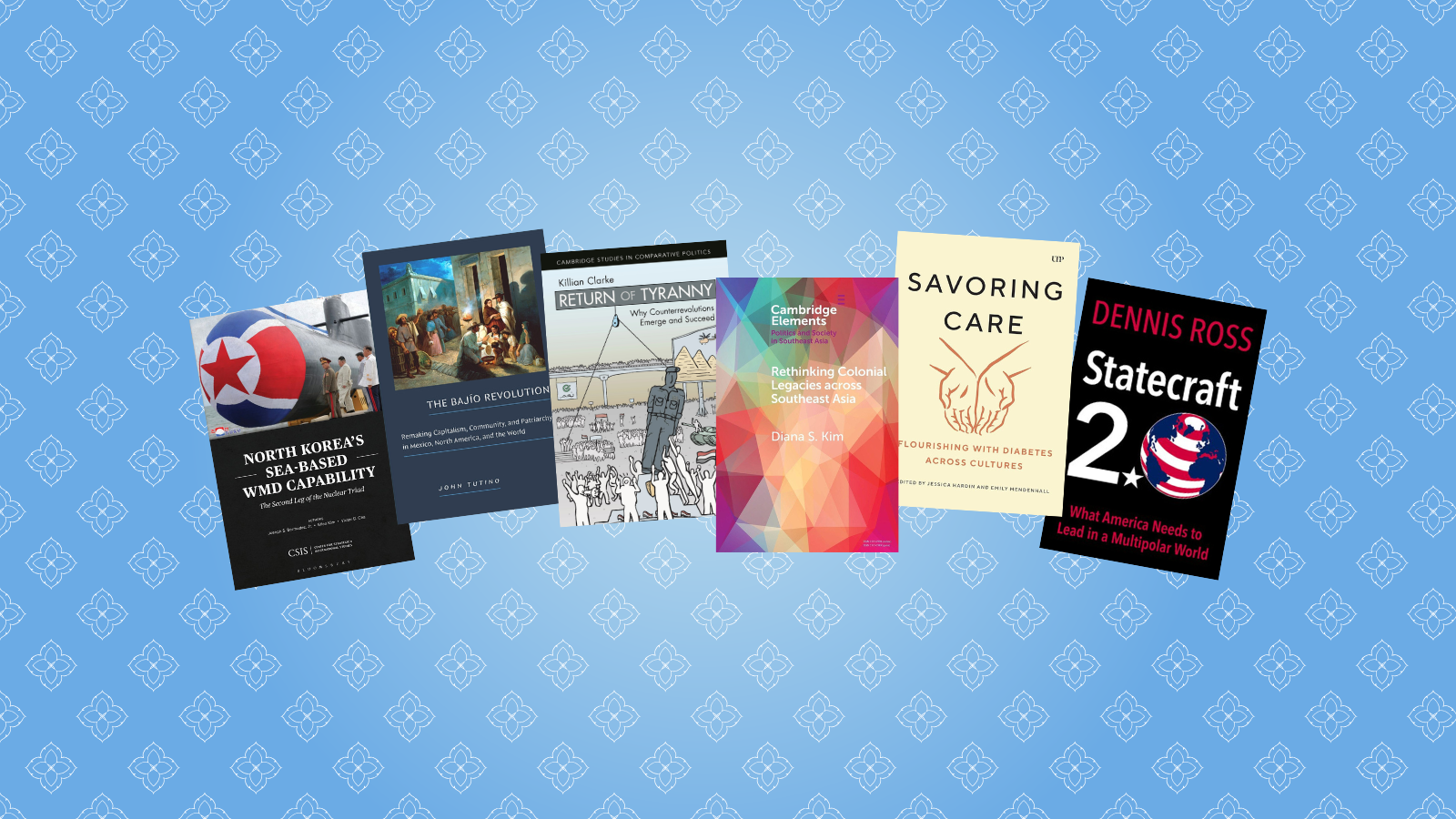 Arrangement of six books against a blue patterned background.