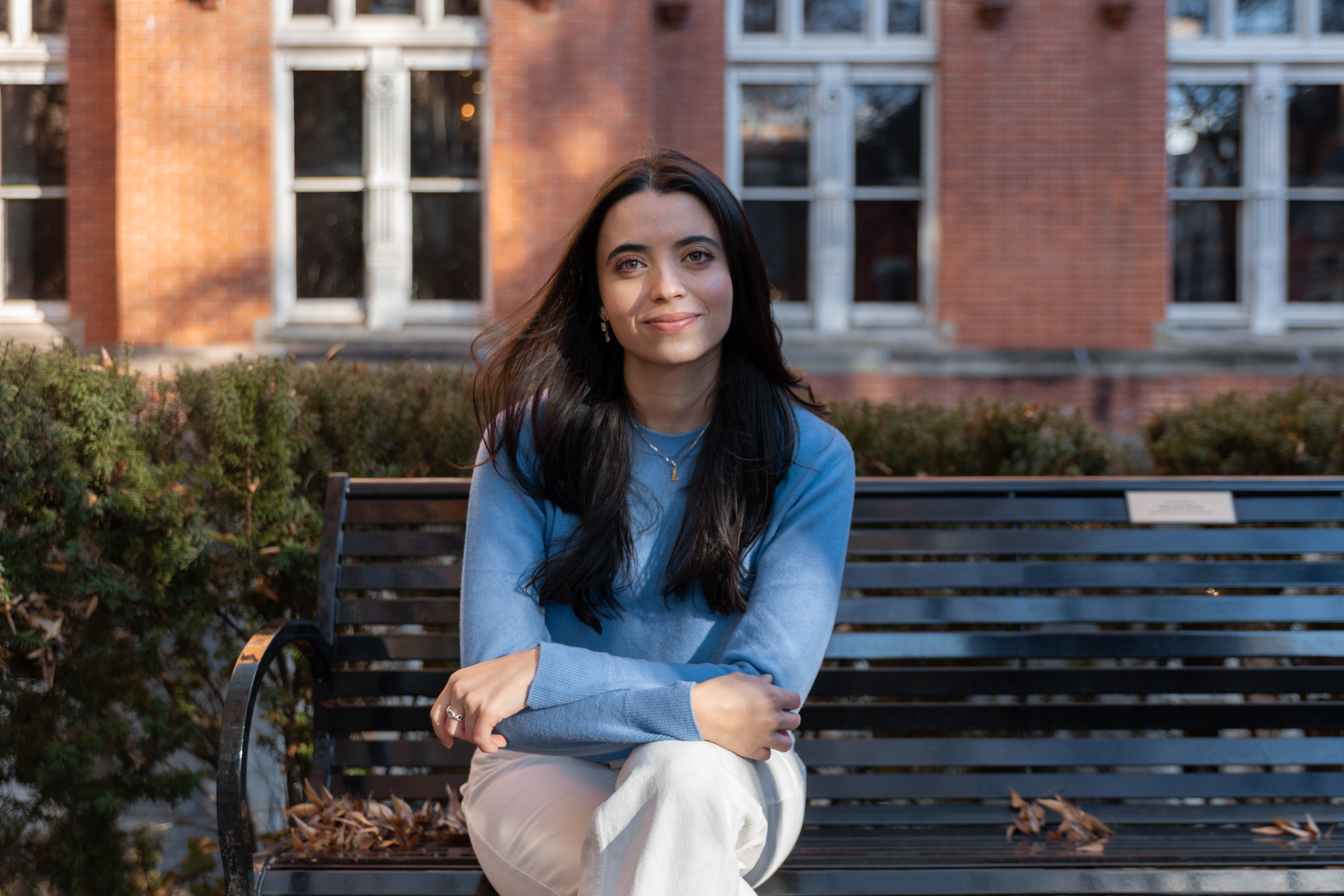 Featured graduate student Luciana Dahdah (MIMR'25) sitting on a bench