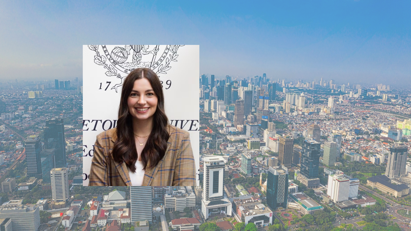 Headshot of a woman with long brown hair in front of the Georgetown logo, against a backdrop of an aerial view of the Jakarta cityscape.