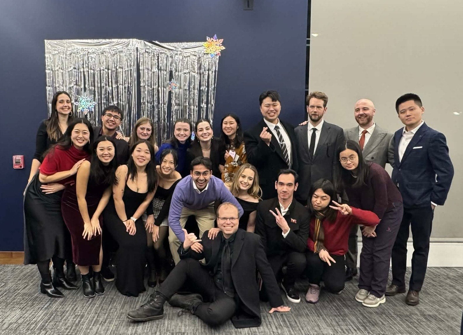 Group of people posing for a photo at a formal event with a decorative backdrop.