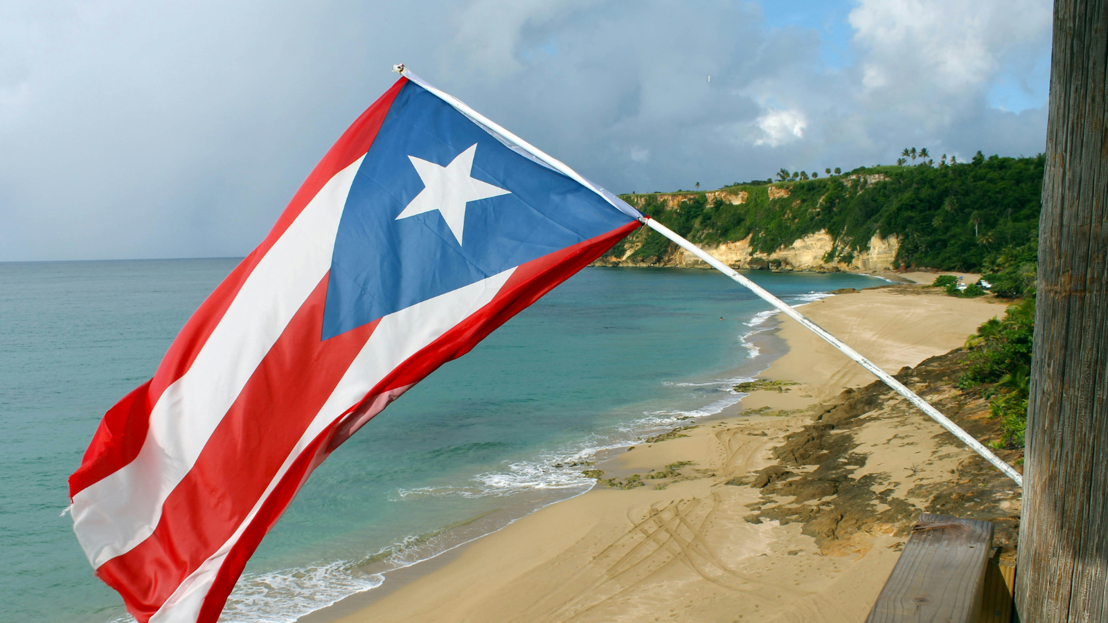 Puerto Rican flag hanging in front of a beachscape.