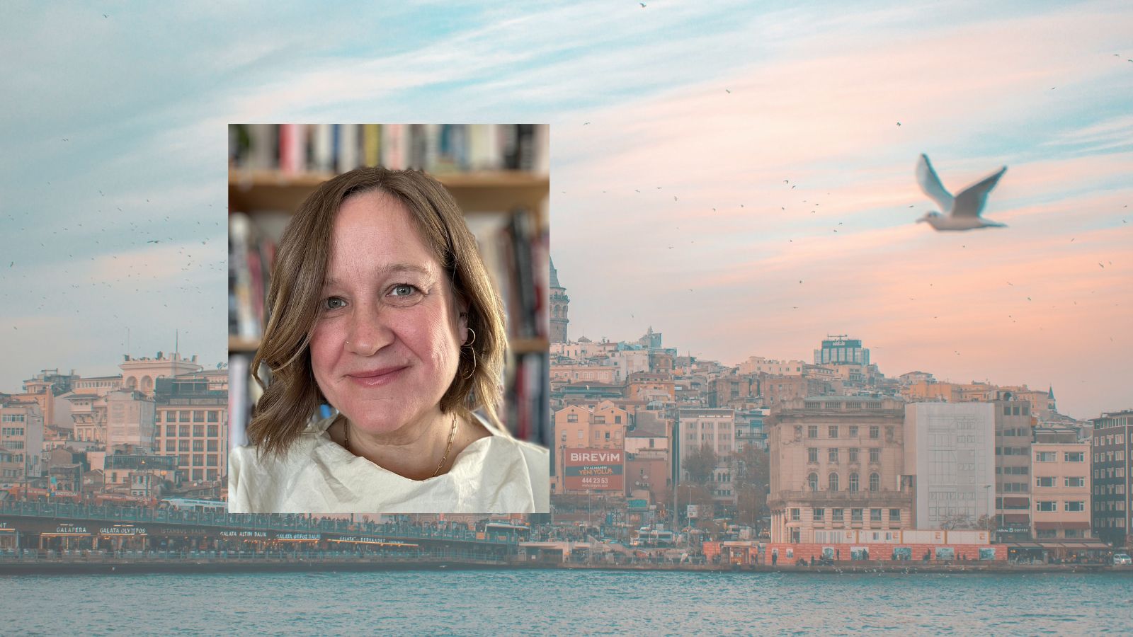 Headshot of a woman with short blonde hair wearing a white top. The background image shows a cityscape with buildings along the water, a seagull flying in the sky, and a person in an inset photo.