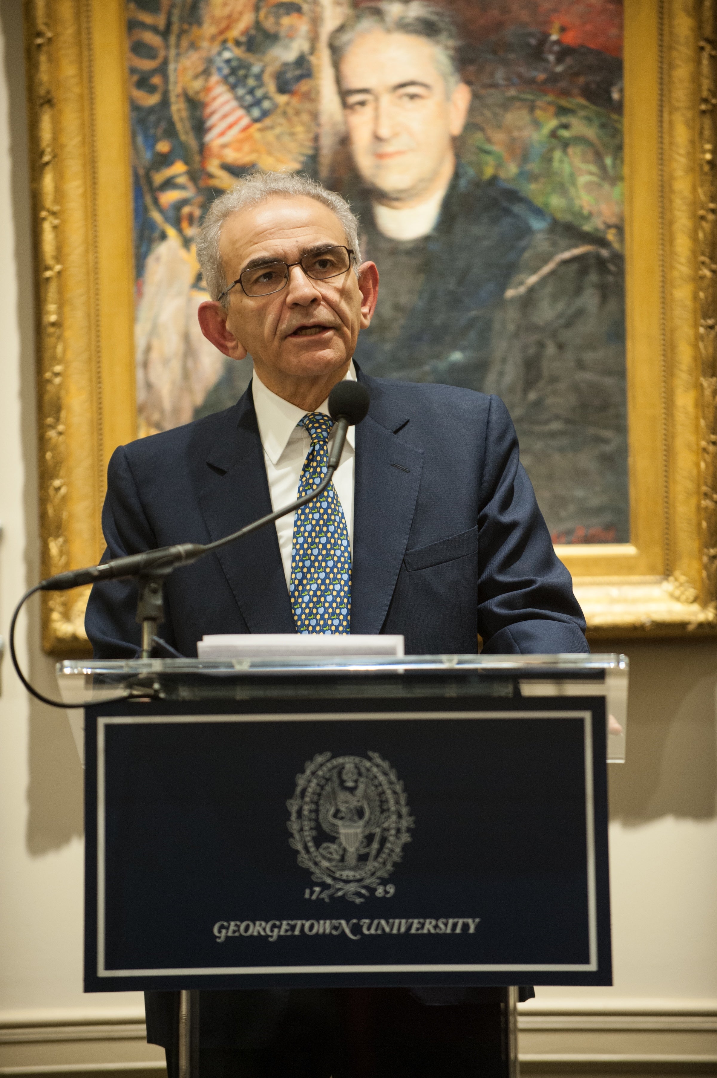 Joseph Sassoon stands at a podium with Georgetown University written on it.