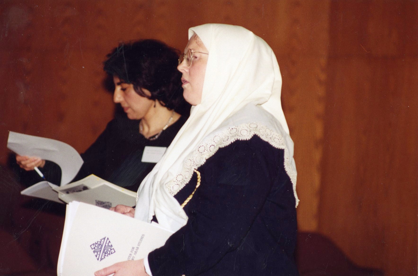 Zeina Azzam and Susan Douglass hold papers with the CCAS logo on it.