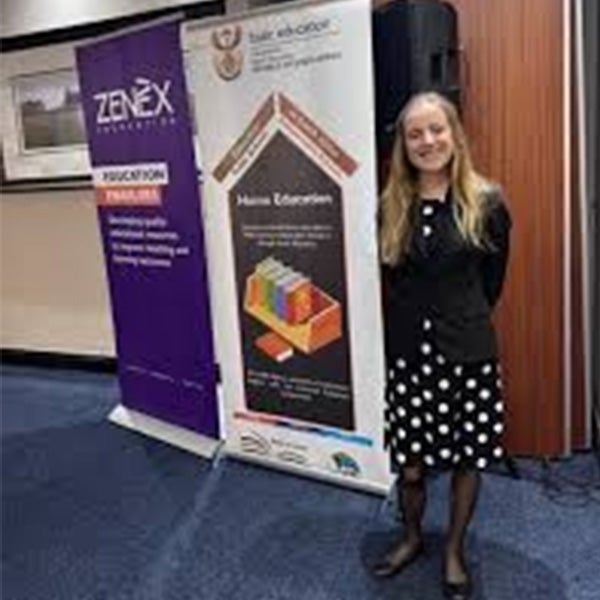 Headshot of Elizabeth standing behind a poster.