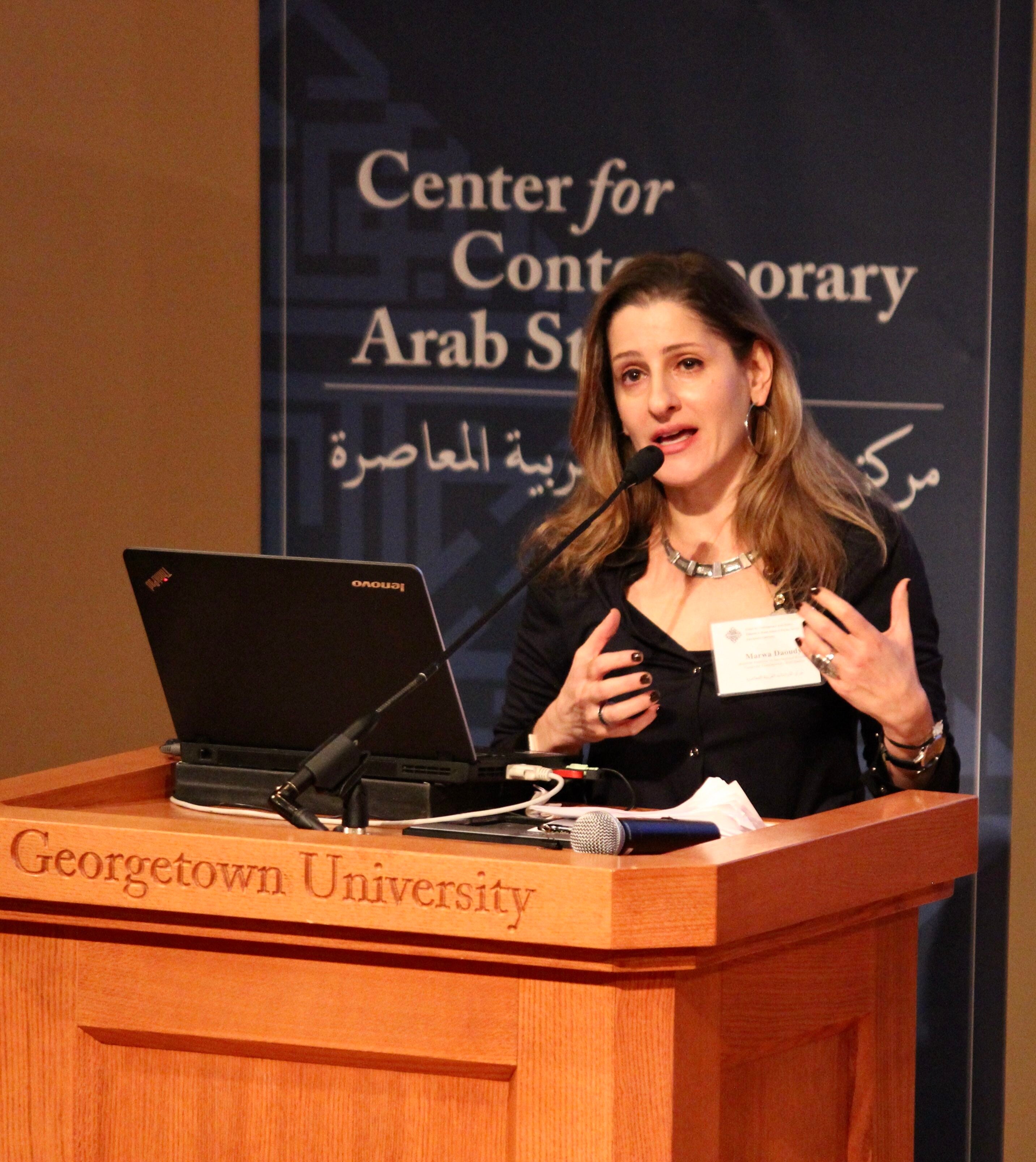 Marwa Daoudy speaks at a podium in front of a banner that says "Center for Contemporary Arab Studies."