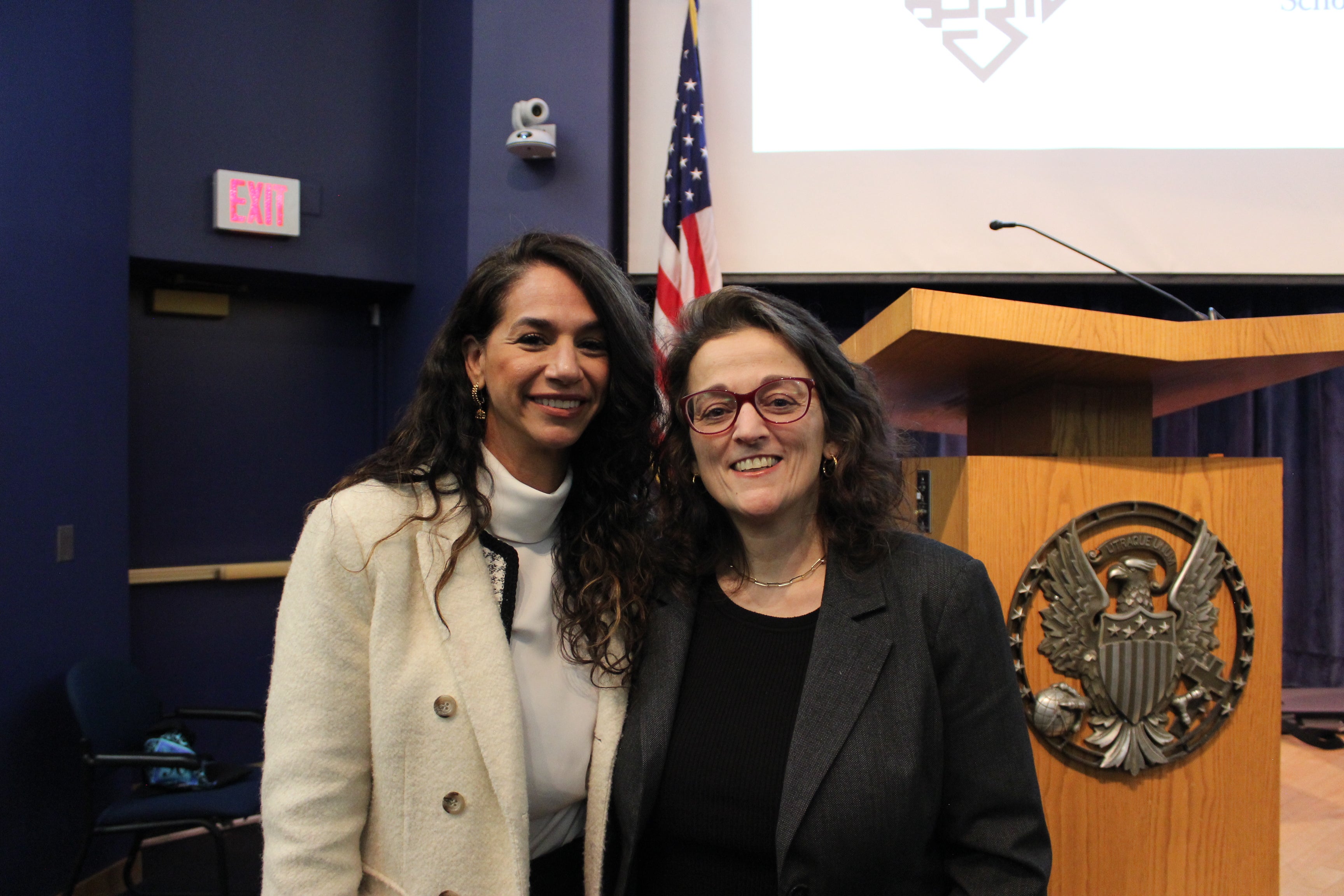 Noura Erakat and Fida Adely stand in front of a podium with the Georgetown seal on it. An American flag is behind them.
