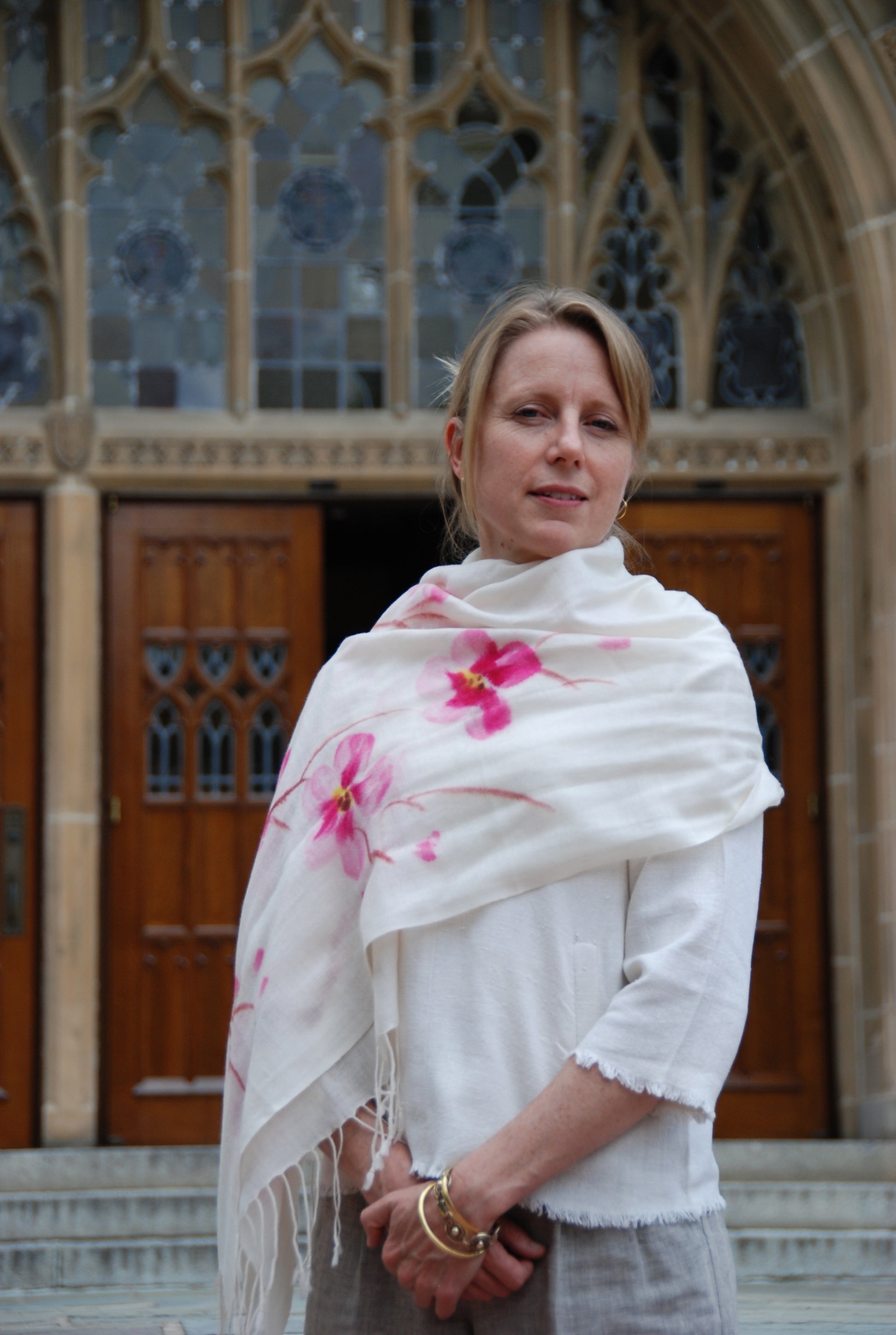 Rochelle Davis stands in front of Copley Hall wearing a pink and white scarf around her neck.