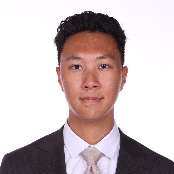 James Wang, short dark hair, light skin, neutral expression, black suit with white shirt and beige tie