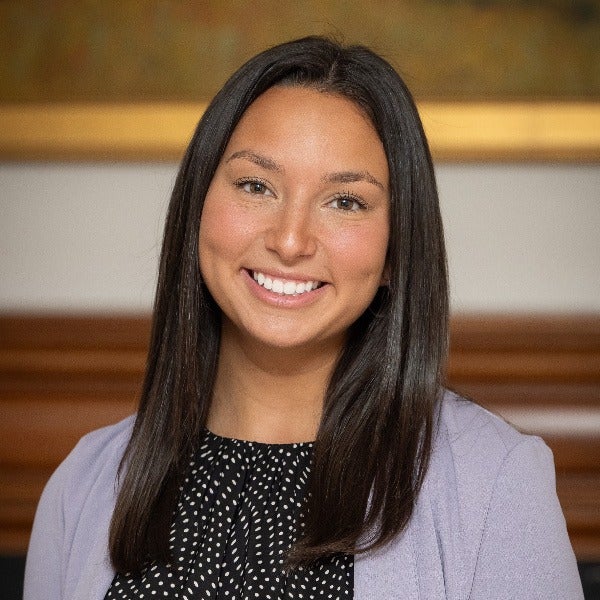 Kylie Litavniks, long dark brown hair, warm smile, light purple blazer, patterned black and white top