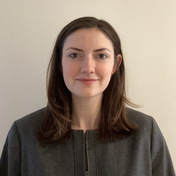 Mary Marsh, brown shoulder-length hair, slight smile, gray sweater, light neutral background