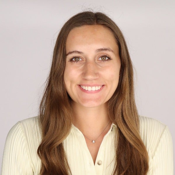 Rachel Rogers, long brown hair, hazel eyes, warm smile, cream ribbed button-up, light background