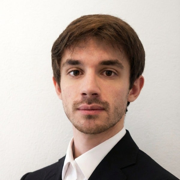 Sergio Campanini, brown hair swept to side, light beard, neutral expression, black suit and white shirt